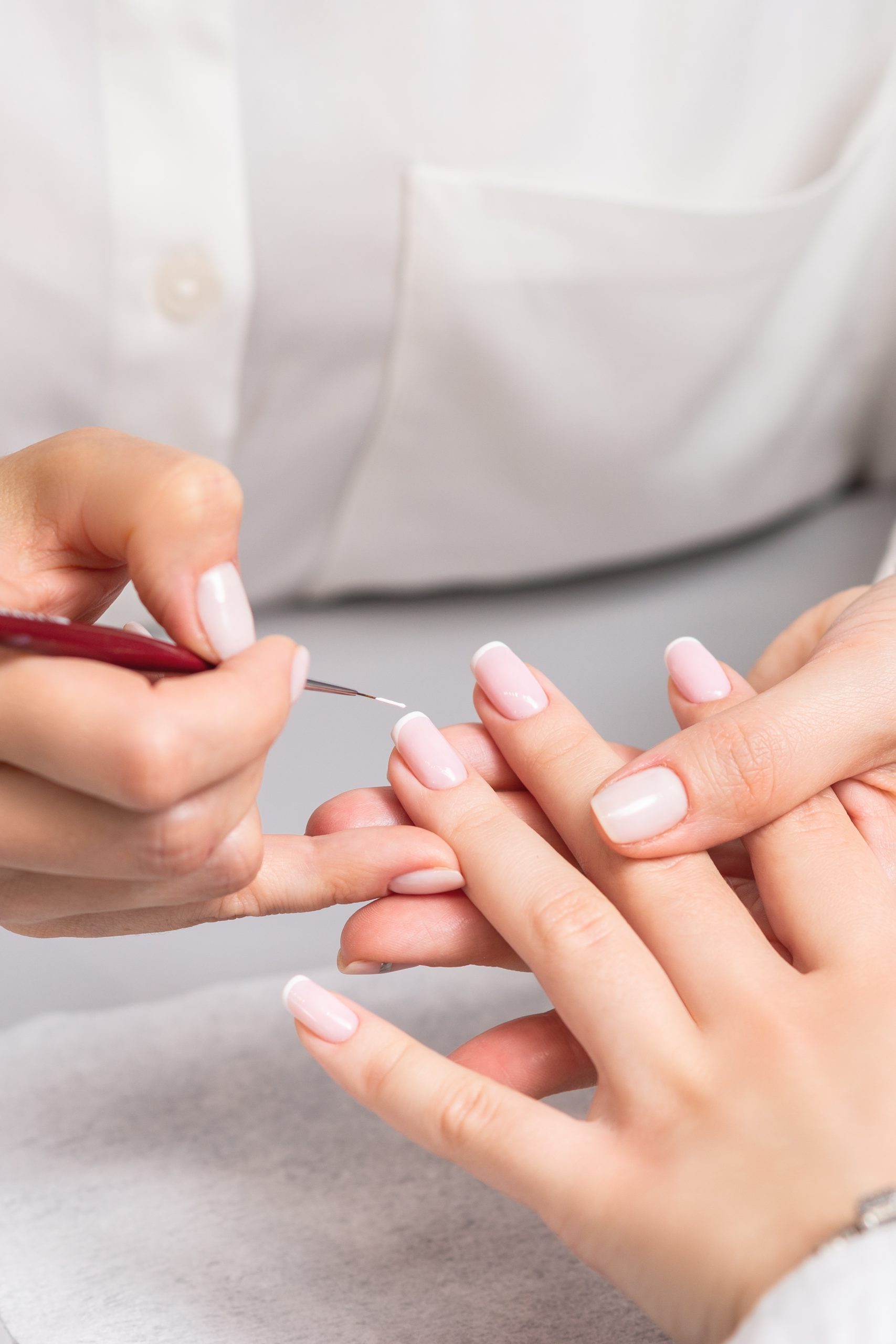 woman receiving french manicure by beautician scaled - Nail Salon 89502