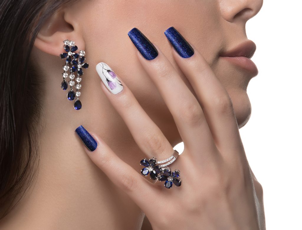 woman with nail art promoting design luxury earrings ring - Nail Salon 89502